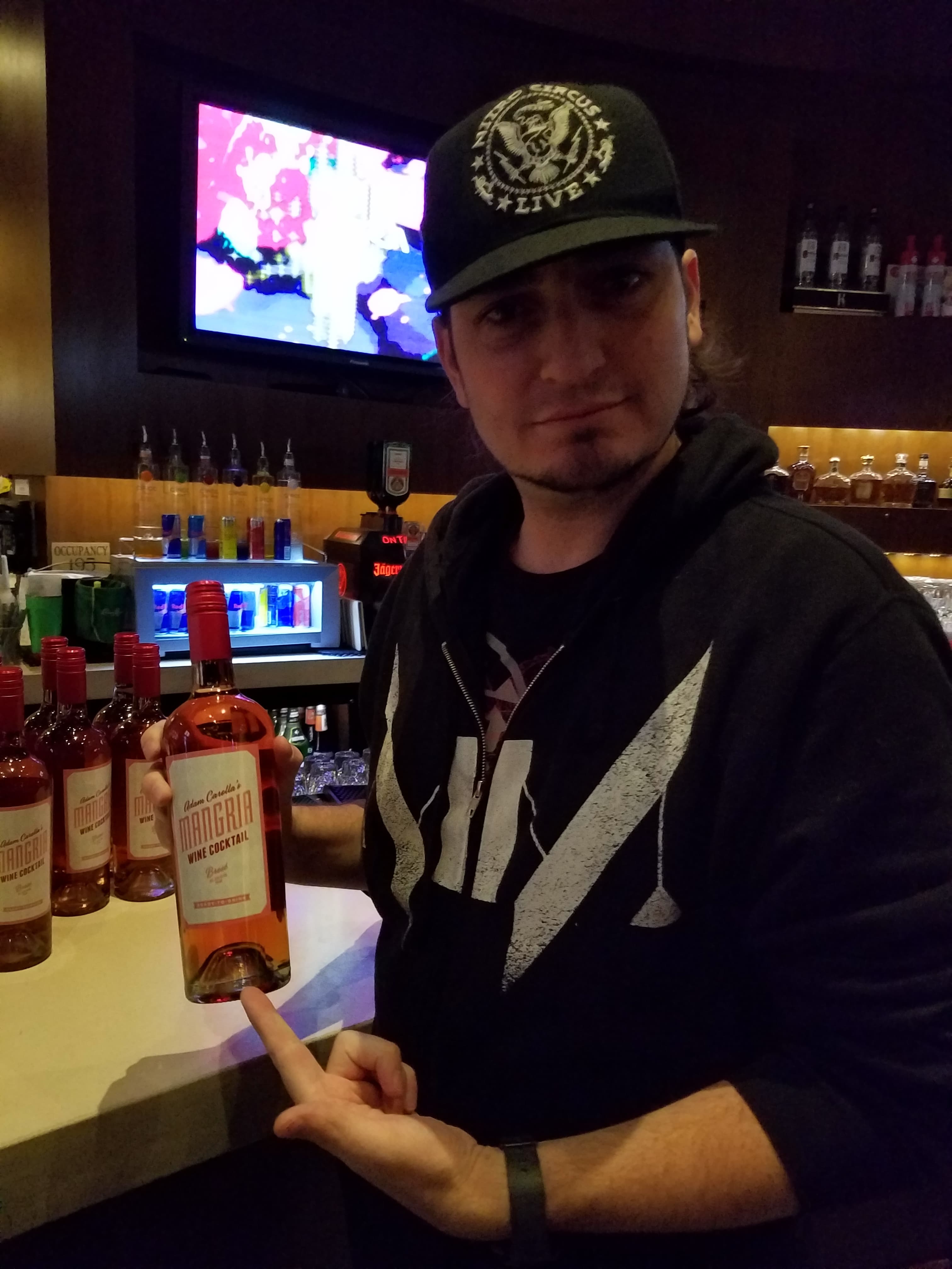 Kronik at the bar holding a bottle during a club gig