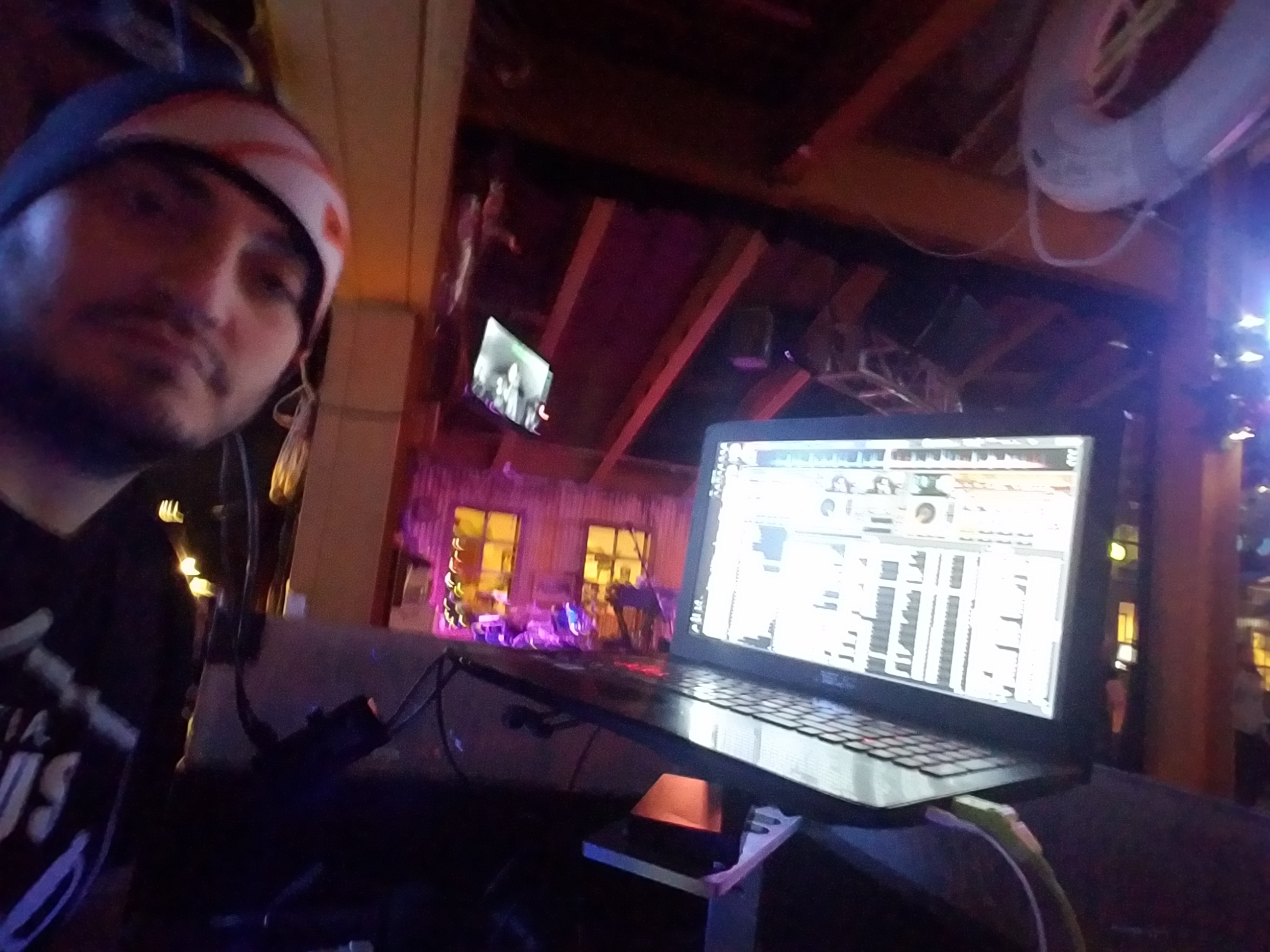 Kronik with DJ laptop setup at a club event with stage lighting