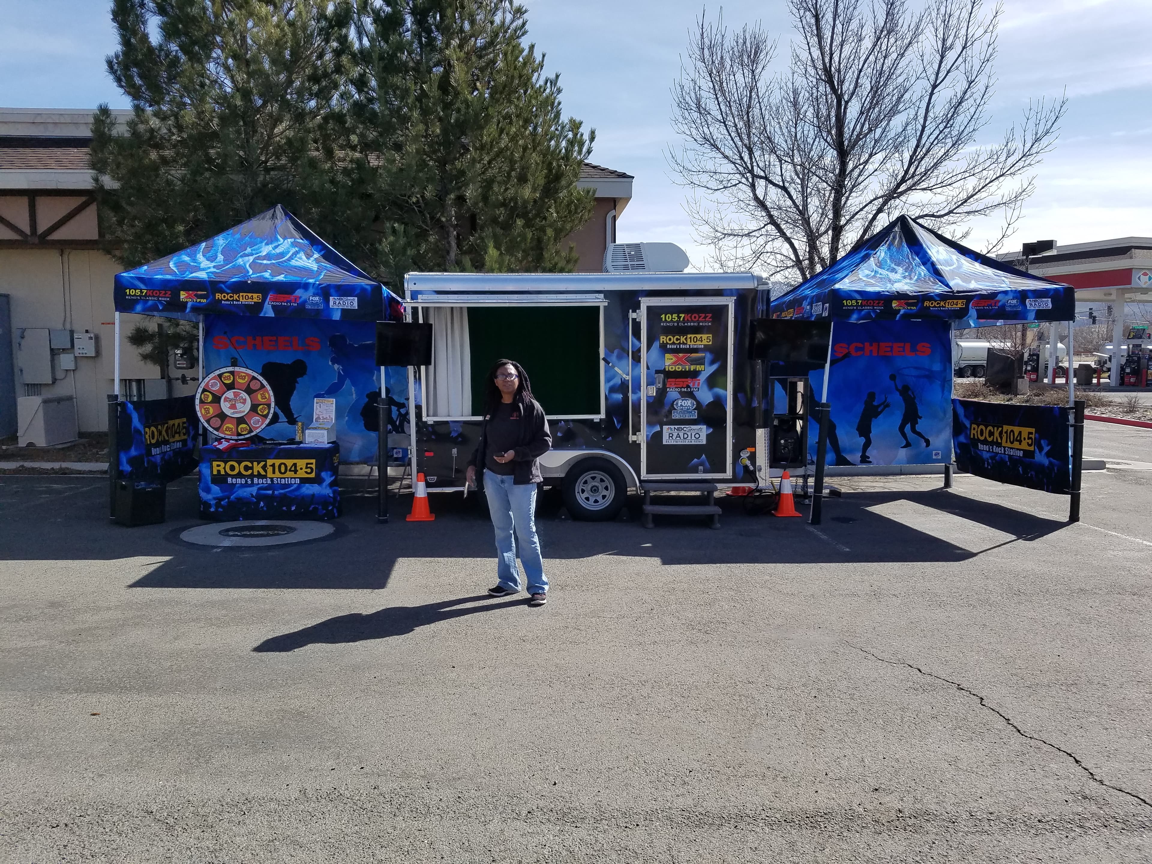 Woman in front of ROCK104.5 KDOT radio promo trailer at outdoor event